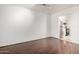 Open living room with hardwood floors leading to a galley kitchen and breakfast bar at 611 E Colgate Dr, Tempe, AZ 85283