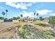 Spacious backyard featuring desert landscaping, lawn, and a covered outdoor kitchen and dining area at 6215 E Surrey Ave, Scottsdale, AZ 85254