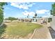 Spacious backyard with lawn, a pool, and a covered patio area for outdoor living at 6215 E Surrey Ave, Scottsdale, AZ 85254