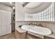 Well-lit bathroom with a jacuzzi tub and a glass block window at 6215 E Surrey Ave, Scottsdale, AZ 85254
