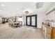 Formal dining room with ornate chandelier, seating for ten, wood-look tile flooring, and decorative wrought iron door at 6215 E Surrey Ave, Scottsdale, AZ 85254