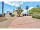 Inviting home with desert landscaping, a private stucco wall, and decorative metal gate along a curved brick driveway at 6215 E Surrey Ave, Scottsdale, AZ 85254