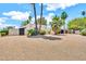 Well-maintained desert landscaping adorns this home's exterior, featuring stucco walls, and palm trees for added privacy at 6215 E Surrey Ave, Scottsdale, AZ 85254
