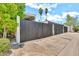 A black-stained wood driveway gate provides privacy to this rural lot at 6215 E Surrey Ave, Scottsdale, AZ 85254