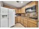 Functional kitchen with wooden cabinetry, granite countertops, and modern appliances at 6215 E Surrey Ave, Scottsdale, AZ 85254