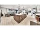 Modern kitchen with a central island, seating, and views of the dining area, featuring elegant chandeliers at 6215 E Surrey Ave, Scottsdale, AZ 85254
