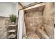 Elegant bathroom shower featuring travertine tile, a built-in bench, and a sleek showerhead at 6215 E Surrey Ave, Scottsdale, AZ 85254
