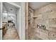 Luxurious shower featuring elegant tile work, a built-in shelf, and a shower bench at 6215 E Surrey Ave, Scottsdale, AZ 85254