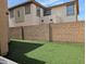 Backyard featuring well-maintained faux grass and a sturdy brick wall for added privacy at 6388 W Ruth Ave, Glendale, AZ 85302