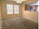 A dining room featuring neutral walls, carpet floors, a modern light fixture, and a kitchen view at 6388 W Ruth Ave, Glendale, AZ 85302