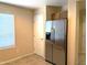 A kitchen with stainless steel refrigerator, tile flooring, a white interior door, and lots of natural light at 6388 W Ruth Ave, Glendale, AZ 85302