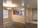 A living room area that shows a large window, carpet flooring, neutral walls, and an open view to the kitchen at 6388 W Ruth Ave, Glendale, AZ 85302