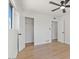 Bright bedroom featuring wood floors, a closet, a ceiling fan, and multiple doors at 6908 E Windsor Ave, Scottsdale, AZ 85257