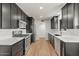 Modern kitchen with stainless steel appliances, dark cabinets, and light wood floors at 6908 E Windsor Ave, Scottsdale, AZ 85257