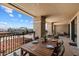 Spacious balcony with comfortable seating and dining table; beautiful city views beyond iron railing at 7181 E Camelback Rd # 702, Scottsdale, AZ 85251