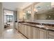 Elegant bathroom with dual sinks, marble countertops, custom cabinetry, and views to the main bedroom at 7181 E Camelback Rd # 702, Scottsdale, AZ 85251