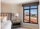 Bedroom view featuring a view through a large window over the tile roofs of the community at 7181 E Camelback Rd # 702, Scottsdale, AZ 85251