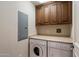 Laundry room featuring washer, dryer, overhead storage cabinets and beige countertop at 7181 E Camelback Rd # 702, Scottsdale, AZ 85251