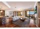 Bright living room with hardwood floors, fireplace, open floorplan, and balcony access at 7181 E Camelback Rd # 702, Scottsdale, AZ 85251