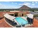 Aerial view of rooftop pool with lounge chairs, umbrellas, and mountain views at 7181 E Camelback Rd # 702, Scottsdale, AZ 85251