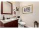 Small bathroom with white sink, decor and cherry-stained cabinets at 7247 W Buckskin Trl, Peoria, AZ 85383