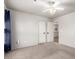 Bedroom with carpeted floors, featuring a ceiling fan and a view into the hallway at 7247 W Buckskin Trl, Peoria, AZ 85383
