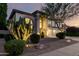 Attractive two-story home with desert landscaping, a three-car garage, and arched windows at 7247 W Buckskin Trl, Peoria, AZ 85383