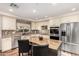 Well-lit kitchen with an island, stainless appliances, decorative backsplash and hardwood floors at 7247 W Buckskin Trl, Peoria, AZ 85383