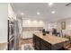 Open kitchen with an island, stainless appliances, decorative backsplash and hardwood floors at 7247 W Buckskin Trl, Peoria, AZ 85383