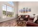 Bright living room showcasing a large window, hardwood floors, and inviting leather sofas at 7247 W Buckskin Trl, Peoria, AZ 85383