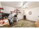 Bright home office with a ceiling fan, hardwood floors, red shelving and a comfortable lounge chair at 7247 W Buckskin Trl, Peoria, AZ 85383