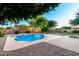 View of backyard pool with blue water and surrounding stone work, including desert landscaping at 7247 W Buckskin Trl, Peoria, AZ 85383