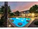 Inviting backyard pool with a small in-water table surrounded by lush desert landscaping at 7247 W Buckskin Trl, Peoria, AZ 85383