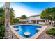 Relaxing pool features a unique design and is surrounded by lush landscaping and the home's exterior at 7247 W Buckskin Trl, Peoria, AZ 85383