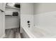 Inviting bathroom featuring a soaking tub, large format tile, and a walk in closet with storage shelves at 7440 E Hubbell St, Scottsdale, AZ 85257