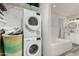 Convenient laundry room featuring a stacked washer/dryer unit and adjacent bathroom with soaking tub at 7440 E Hubbell St, Scottsdale, AZ 85257