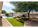 Backyard view with pool, lawn, mature trees, and lounge chairs for relaxing outdoors at 7440 E Hubbell St, Scottsdale, AZ 85257