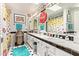 Unique bathroom with a Coca-Cola theme, vintage decor, double sinks, and bright black and white tile at 7722 W Michigan Ave, Glendale, AZ 85308