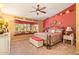 Comfortable bedroom with colorful decor, decorative ceiling fan, window nook, and ample space at 7722 W Michigan Ave, Glendale, AZ 85308