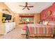 Spacious bedroom with decorative ceiling fan, window nook, dresser, and beautiful natural lighting at 7722 W Michigan Ave, Glendale, AZ 85308