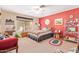The bedroom showcases vibrant red walls, a cozy bed, and lots of natural light from the window at 7722 W Michigan Ave, Glendale, AZ 85308