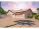 Spacious three-car garage with long driveway and desert landscaping at 7722 W Michigan Ave, Glendale, AZ 85308