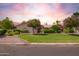 Charming home with a well-manicured lawn, decorative bushes, and flowering trees at 7722 W Michigan Ave, Glendale, AZ 85308