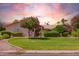 Beautiful front lawn with healthy green grass, mature trees, and decorative bushes at 7722 W Michigan Ave, Glendale, AZ 85308