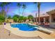 Sparkling pool with diving board surrounded by lush landscaping and desert flora at 7722 W Michigan Ave, Glendale, AZ 85308