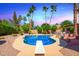 Private swimming pool surrounded by desert landscaping and mature palm trees at 7722 W Michigan Ave, Glendale, AZ 85308