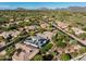 Aerial view showcasing houses in a lush, green desert community, with mountains in the background at 7775 E Fledgling Dr, Scottsdale, AZ 85255