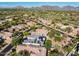 Stunning aerial view of a desert home featuring solar panels and a well-manicured lawn with mountain views at 7775 E Fledgling Dr, Scottsdale, AZ 85255