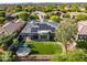 A high angle showing the solar-paneled roof, well-kept lawn, and verdant trees that surround this single Gathering home at 7775 E Fledgling Dr, Scottsdale, AZ 85255