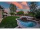 Backyard showcasing artificial lawn, inground spa with waterfall feature, and privacy fence at 7775 E Fledgling Dr, Scottsdale, AZ 85255